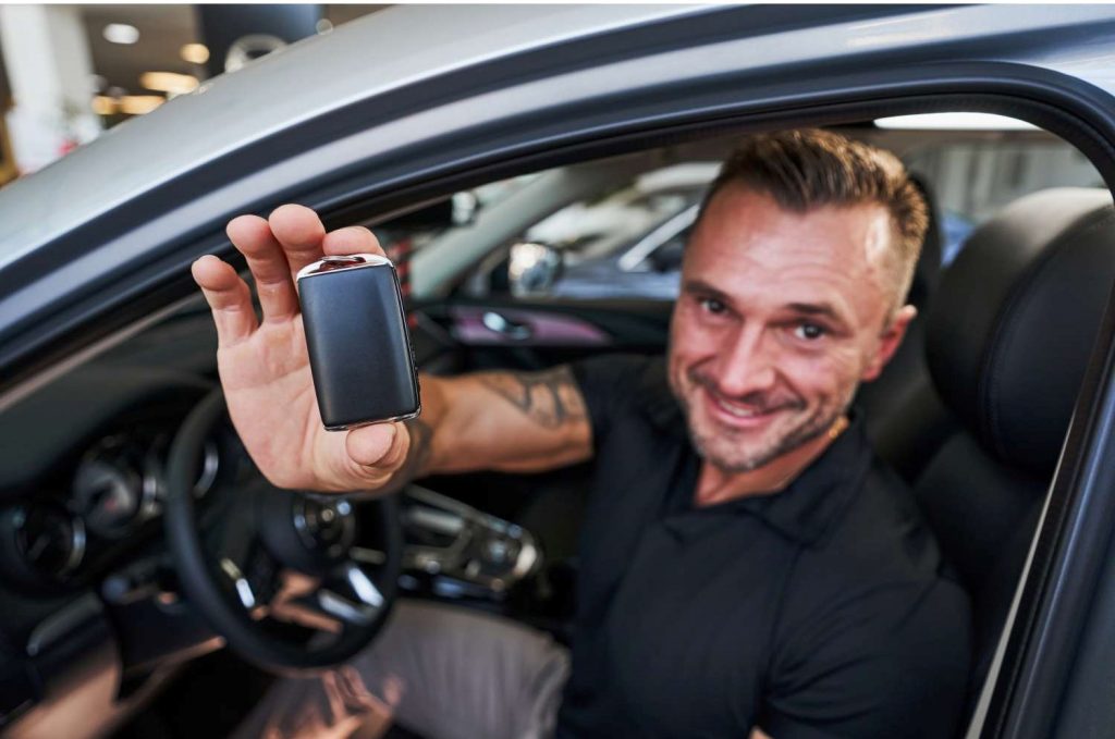Man sitting in car smiling at camera | Featured image for the Easy Car Finance page from eCarz.