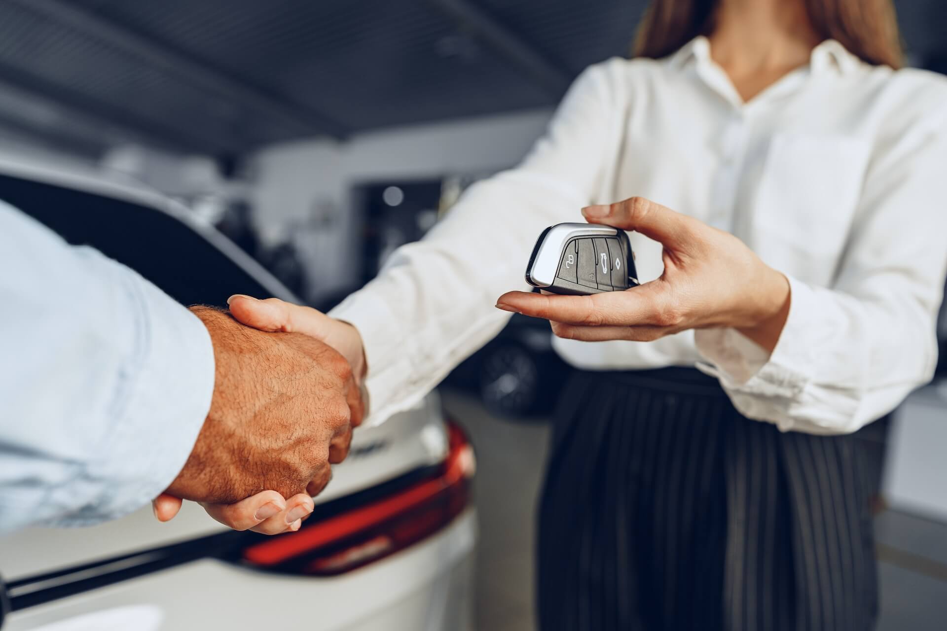 Person receiving keys after buying a car for the first time | Featured image for the Buying a Car for The First Time Blog from eCarz.