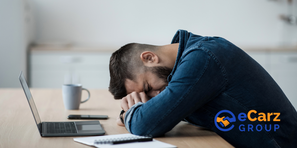 Man with head on desk - How to Avoid Common Car Financing Mistakes